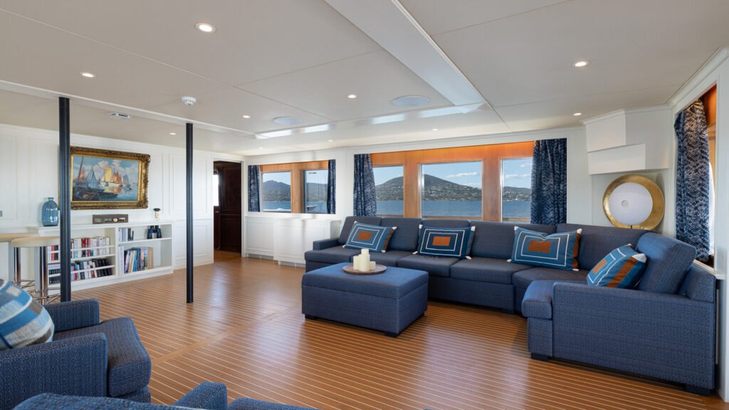 Main lounge with blue sofas and framed artwork