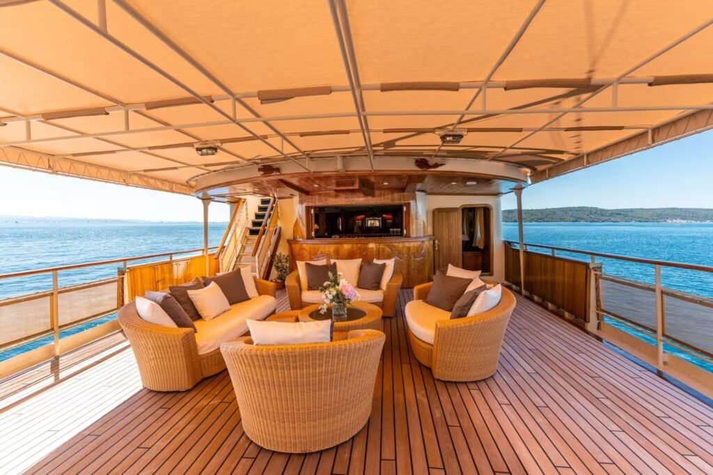 classic yacht for charter with jet skis, bow view underway