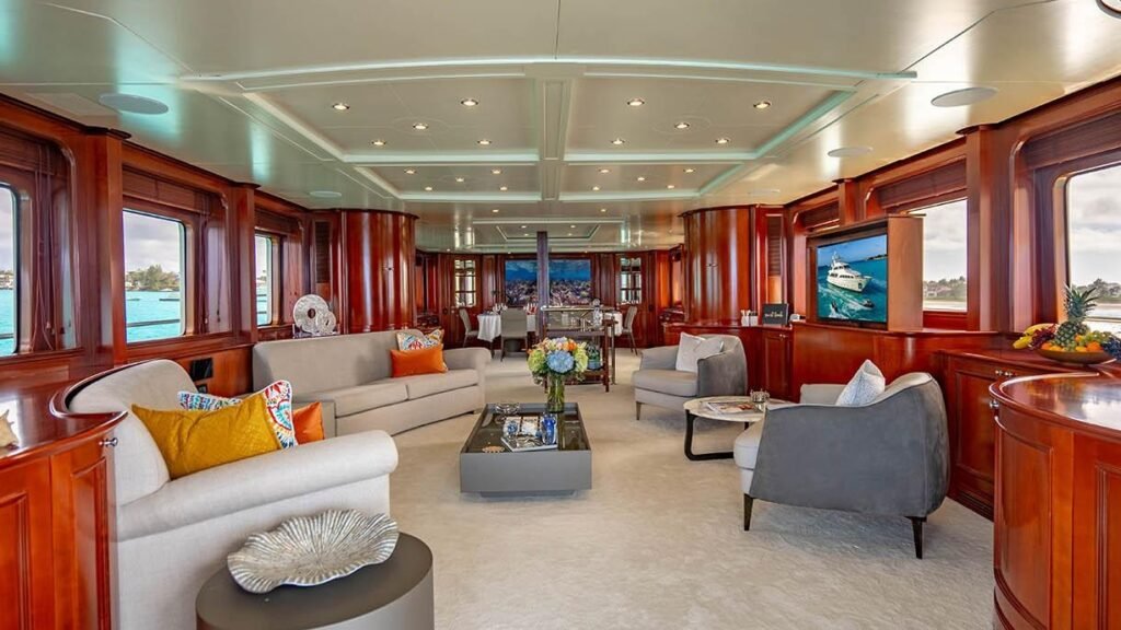 Main salon lounge with sofas, fresh flowers and wall-mounted television