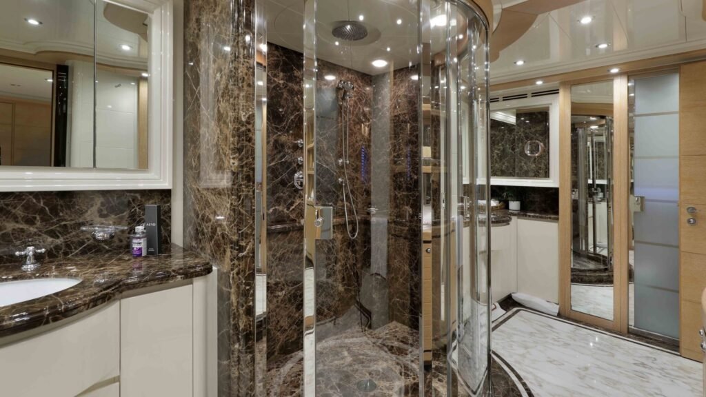 Master bathroom with dark marble shower and AERO-branded amenities