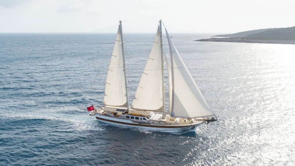 Sailing yacht at anchor near Malaga, Costa del Sol, Mediterranean sea and limestone headland