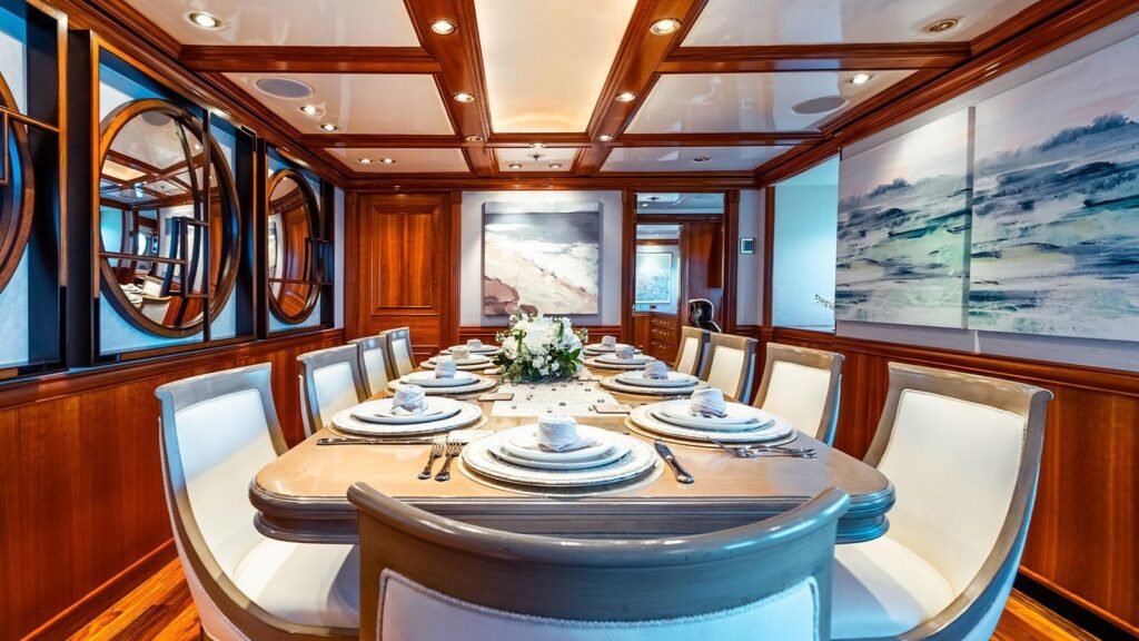Formal dining room aboard LEVERAGE with oval table and circular mirrors