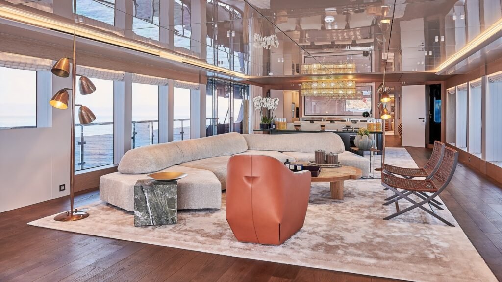 Main salon aboard ONE ZERO with curved cream sofa and backlit bar