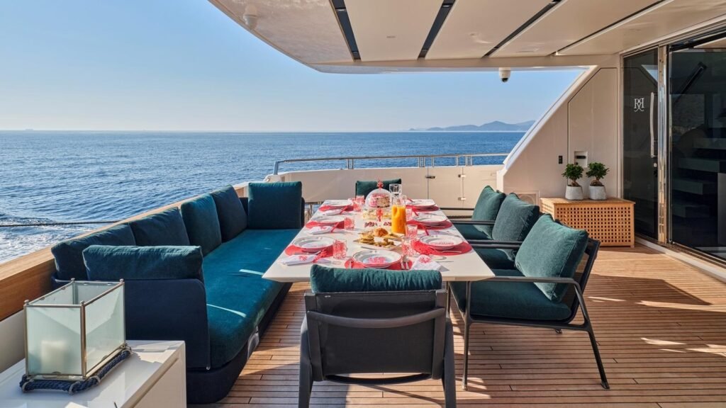 Aft deck dining aboard RIANA II with teal banquettes