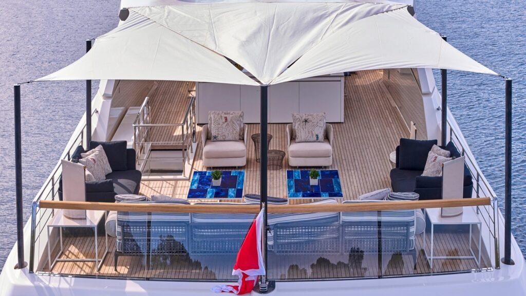 Sundeck aboard RIANA II under a white shade sail with settees and sunpads