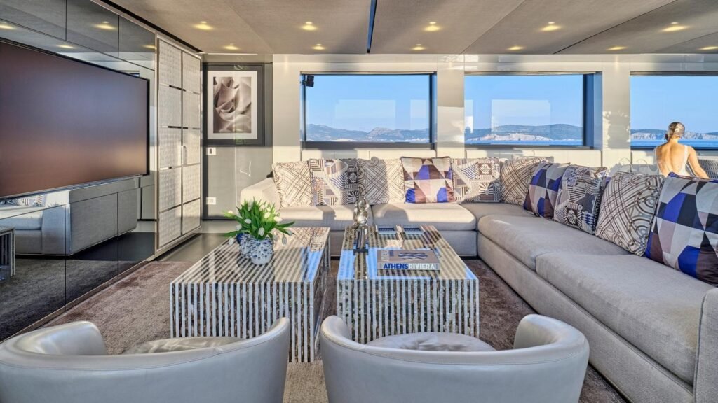 Main salon aboard RIANA II with sectional settee and mirrored low tables