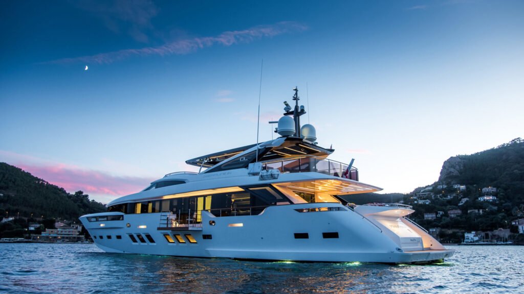 SOULMATE motor yacht exterior at twilight with hillside backdrop