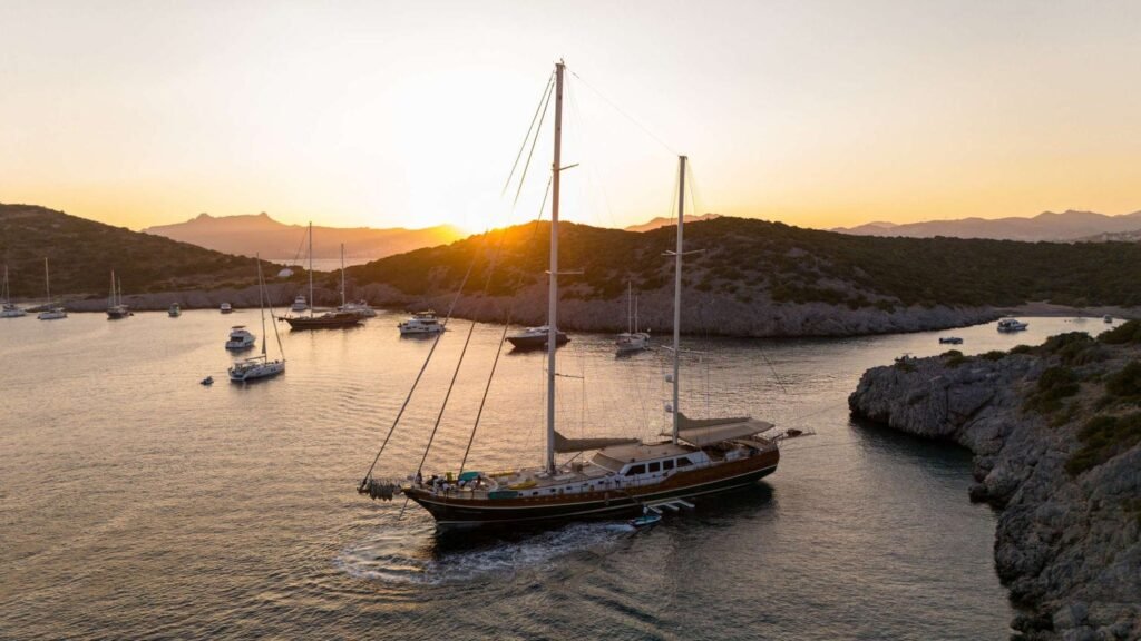 La Bella Vita motor sailing gulet at anchor in a sheltered cove at sunset, aerial view